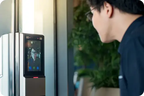 Man using a facial recognition access control system for secure entry into a building.
